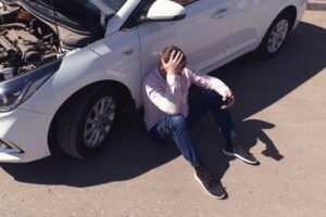 boy sitting near accident car