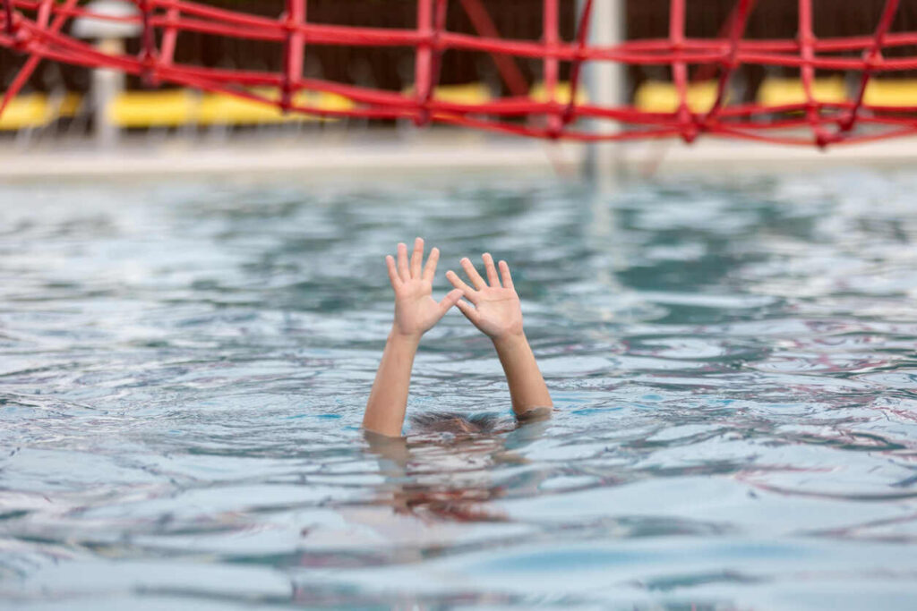 Two hands desperately reaching out of rippling water, symbolizing a tragic drowning accident and the legal options available to affected families in North Carolina.