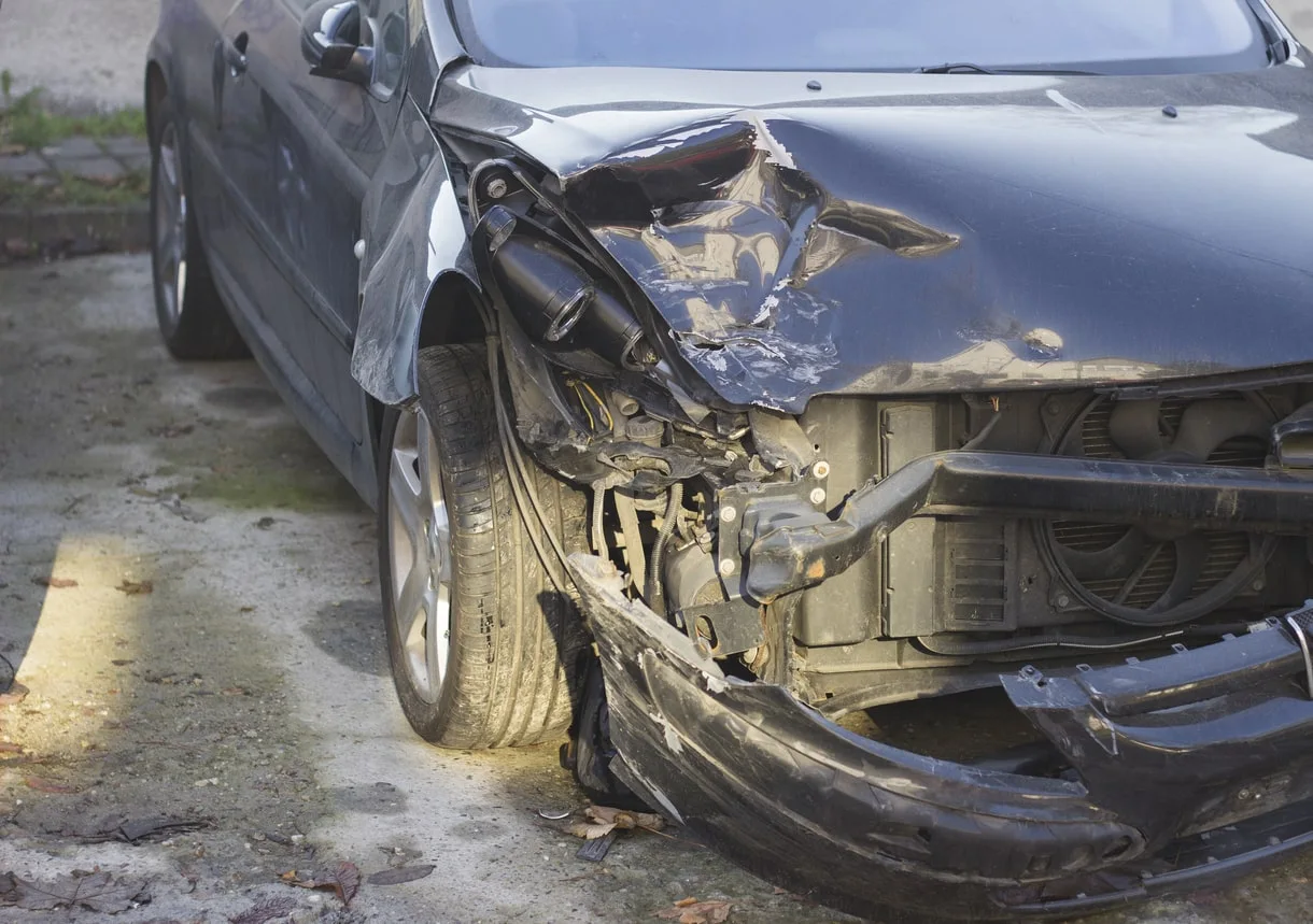 Damaged car front showing impact from a collision, illustrating a delivery driver accident with potential injury.