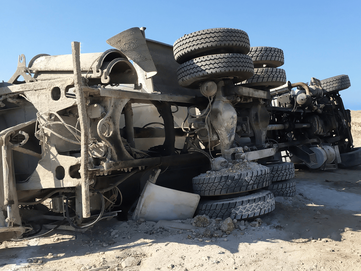 An overturned truck with exposed wheels and damaged undercarriage